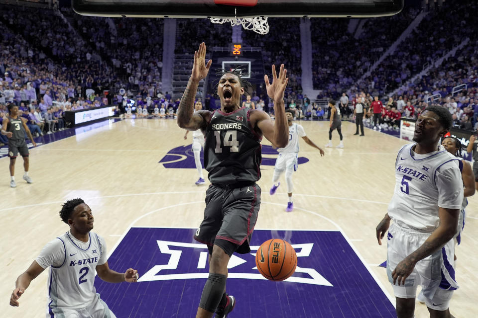 Oklahoma forward Jalon Moore (14) gets past Kansas State guard Tylor Perry (2) and guard Cam Carter (5) to dunk the ball during the first half of an NCAA college basketball game Tuesday, Jan. 30, 2024, in Manhattan, Kan. (AP Photo/Charlie Riedel)