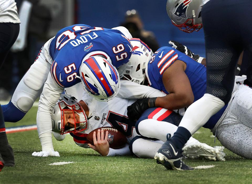 Patriots quarterback Bailey Zappe is sacked by the Bills' Leonard Floyd (56) and Ed Oliver (91) during Sunday's game. Zappe was pressured much of the game and sacked three times. He also threw three interceptions.