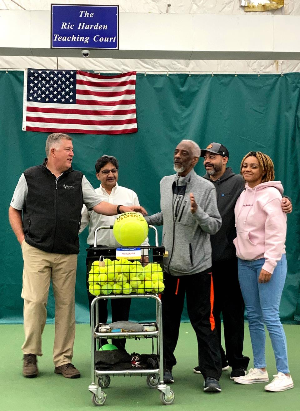 The late Ric Harden (center), Westwood Racquet Club's former tennis director, speaks during a May 19, 2022, ceremony, when one of the club's seven courts was named in his honor. Also appearing are, from left: Westwood owner Tom Pakulski; Jeet Sabherwal; Patrick Harden, his son; and Raina Harden, his granddaughter. Harden died July 31 at age 75.