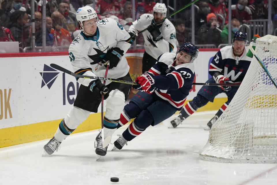 San Jose Sharks defenseman Nicolas Meloche (53) and Washington Capitals left wing Conor Sheary (73) fight for the puck during the first period of an NHL hockey game, Wednesday, Jan. 26, 2022, in Washington. (AP Photo/Evan Vucci)