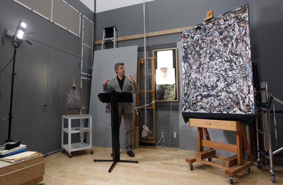 Nicholas Dorman, chief conservator for the Seattle Art Museum, talks about his on-going restoration work of Jackson Pollock's painting Sea Change during a news conference Tuesday, Nov. 27, 2012, at the museum in Seattle. The celebrated piece, part of SAM's permanent collection, was painted in 1947 and altered in 1970 with a coat of varnish. Dorman is several months into the restoration work, which is complicated by the uneven surface and multiple layers of media, including several types of paint and imbedded gravel. The restoration is sponsored by Bank of America's Art Conservation Project, which enabled SAM staff and consulting experts to undertake a study of the original materials and evaluate the impact of materials used in conservation treatments. (AP Photo/Elaine Thompson)