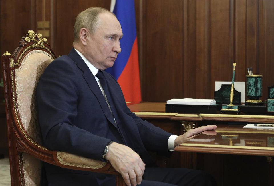 Russian President Vladimir Putin, in gilt chair, at a meeting.