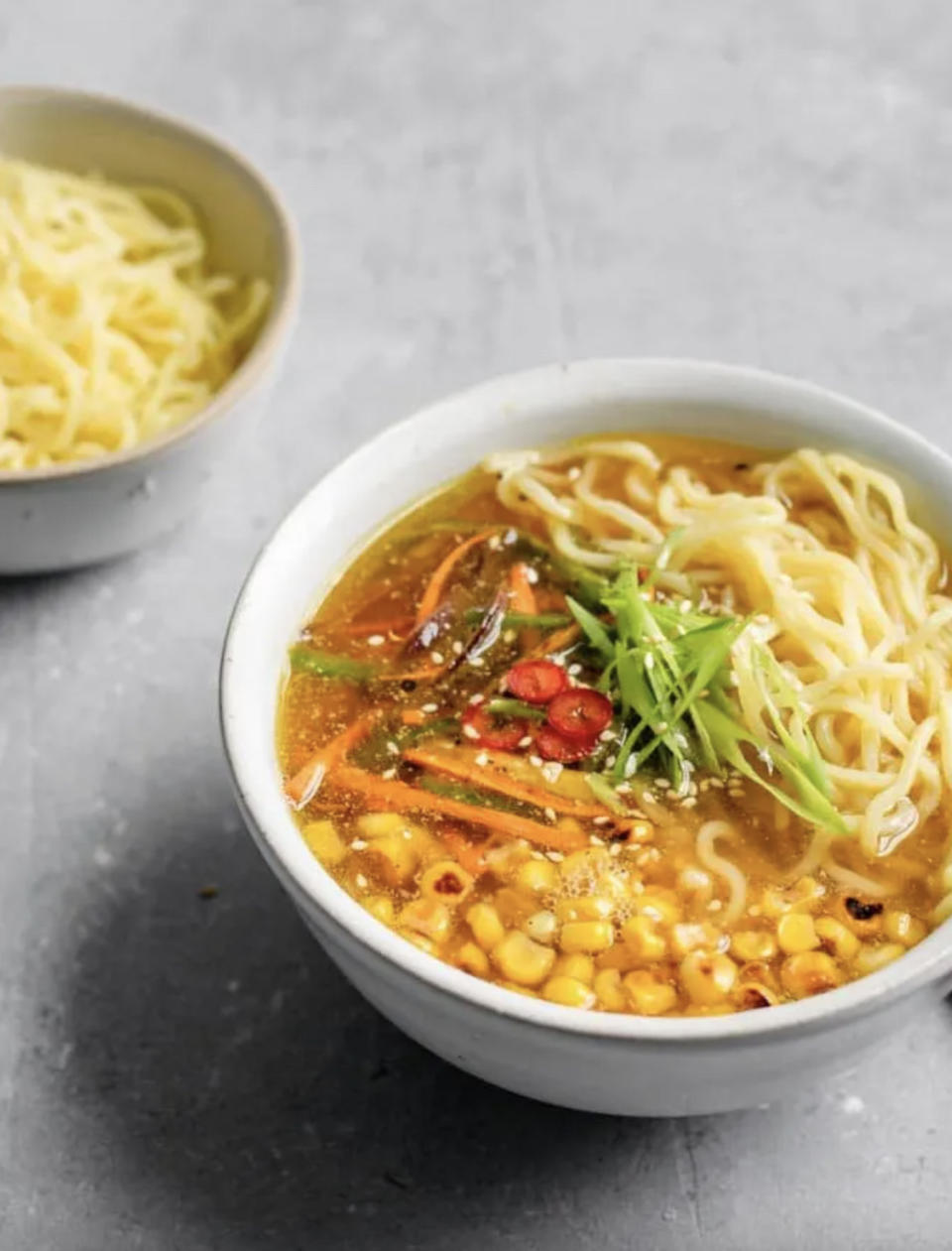 Noodle soup with corn, miso tahini broth, and greens in a bowl