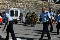 Israeli security forces gather at the site of an attack at a checkpoint near the Israeli settlement of Har Homa, in the occupied West Bank, on February 14, 2016