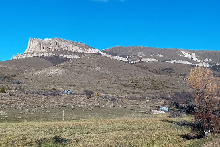 Paredones de 100 metros formados por cenizas volcánicas, pequeñas piedras y cientos de bloques de roca en el cerro La Buitrera; al pie, la estancia La Lucha
