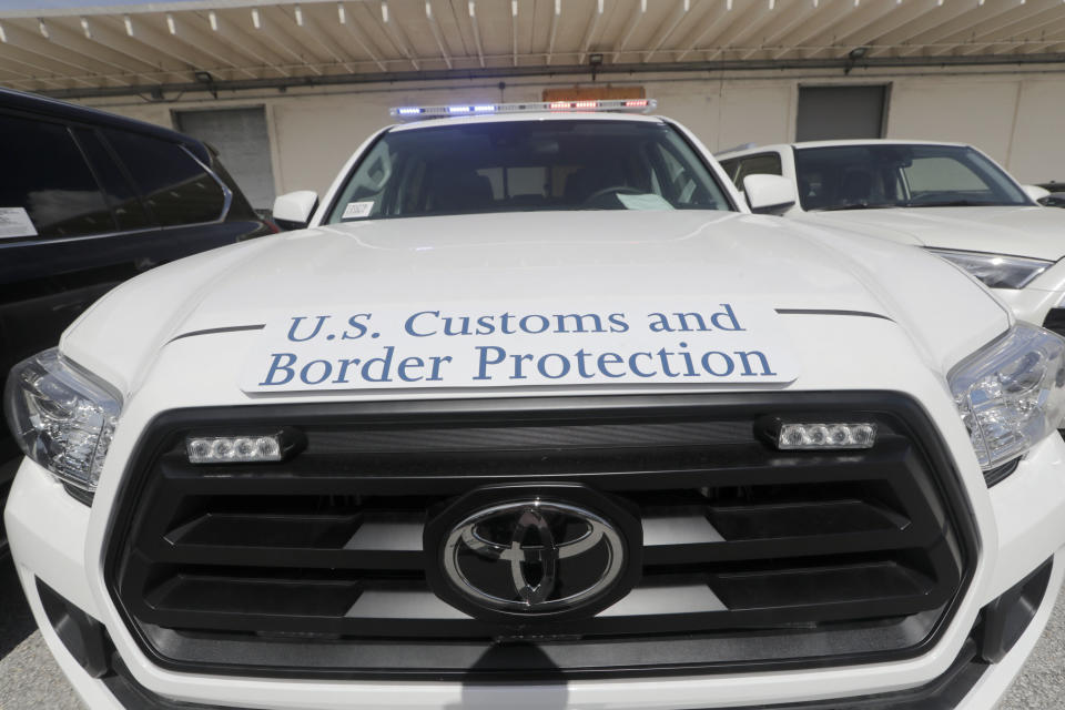 A Toyota Tacoma with flashing lights sits among vehicles worth an estimated $3.2 million, at Port Everglades after they were seized by Homeland Security Investigations, Wednesday, July 8, 2020, in Fort Lauderdale, Fla. The vehicles were to be smuggled to Venezuela in violation of U.S. export laws and sanctions against the socialist Venezuelan Government. (AP Photo/Lynne Sladky)