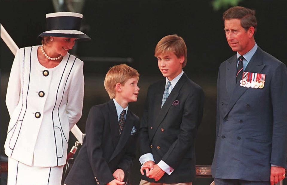 Princess Diana, her sons Harry and William, and Prince Charles watch a parade march outside Buckingham Palace as part of the commemorations of VJ Day in August 1995 in London.