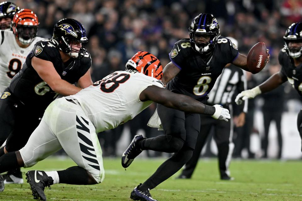 Ravens quarterback Lamar Jackson (8) stiff-arms Bengals defensive tackle DJ Reader during the third quarter of their game at M&T Bank Stadium in Baltimore on Nov. 16, 2023.