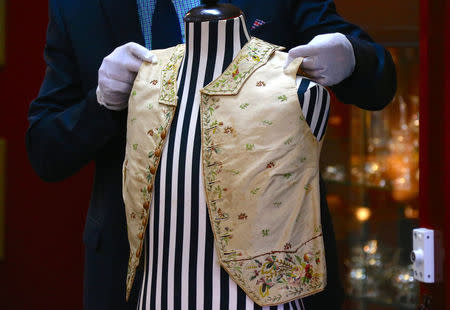 Julian Aalders from Aalders Auctions house adjusts a 250-year-old embroidered silk waistcoat that belonged to Captain James Cook on a mannequin during a display in Sydney, Australia, March 22, 2017. REUTERS/David Gray