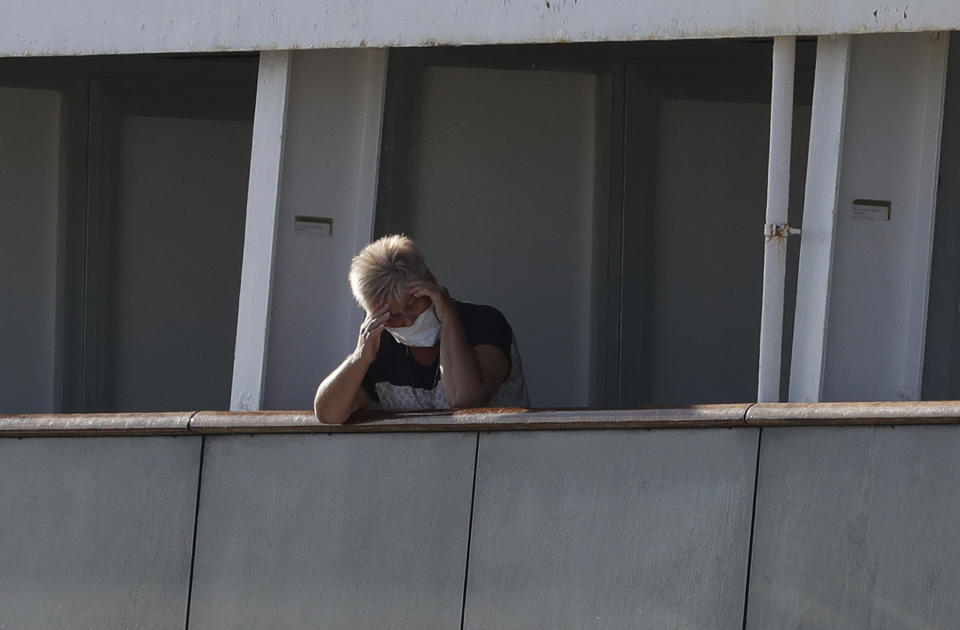 A passenger looks off her balcony aboard the cruise ship Rotterdam as they wait to disembark at Port Everglades during the new coronavirus pandemic, Thursday, April 2, 2020, in Fort Lauderdale, Fla. Those passengers that are fit for travel in accordance with guidelines from the U.S. Centers for Disease Control will be permitted to disembark. (AP Photo/Lynne Sladky)