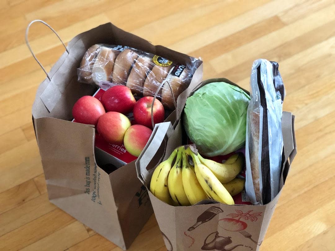 Two bags full of food groceries on the floor. (Stock Image) 