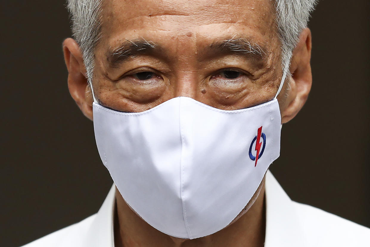 People's Action Party Secretary-General and Singaporean Prime Minister Lee Hsien Loong wears a mask adorned with his party logo as he waits to field questions from the media at a nomination center ahead of the general election in Singapore, Tuesday, June 30, 2020. Campaigning has begun for Singapore’s general elections, with the opposition hoping to dent the ruling party’s supermajority in parliament with support from Prime Minister Lee’s estranged younger brother. (AP Photo/Yong Teck Lim)