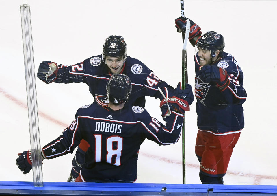 Columbus Blue Jackets center Pierre-Luc Dubois (18) celebrates his game winning goal against the Toronto Maple Leafs with teammates Alexandre Texier (42) and Cam Atkinson (13) during overtime in an NHL hockey playoff game Thursday, Aug. 6, 2020, in Toronto. (Nathan Denette/The Canadian Press via AP)