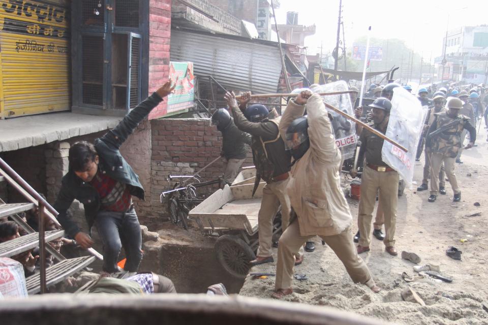 TOPSHOT - In this photo taken on December 19, 2019 police beat protesters with sticks during a demonstration against India's new citizenship law in Lucknow. - Indians defied bans on assembly on December 19 in cities nationwide as anger swells against a citizenship law seen as discriminatory against Muslims, following days of protests, clashes and riots that have left six dead. (Photo by STR / AFP) (Photo by STR/AFP via Getty Images)