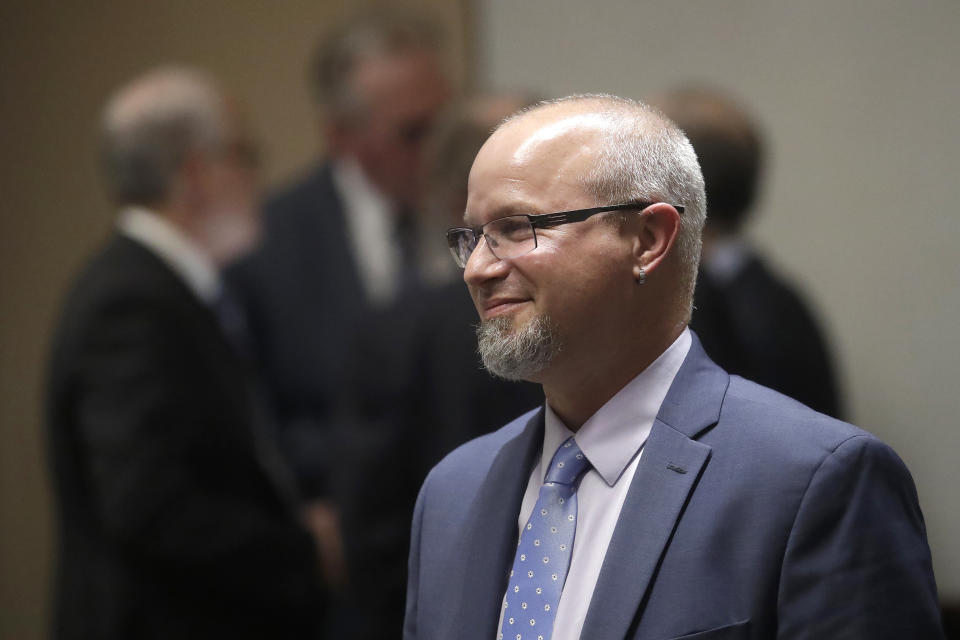 FILE - In this Feb. 25, 2020, file photo, wildfire victim Will Abrams smiles during a break from Pacific Gas & Electric CEO Bill Johnson testifying at the California Public Utilities Commission in San Francisco. The nation's largest utility limped into bankruptcy vilified for its long-running neglect of a crumbling electrical grid that ignited horrific Northern California wildfires. It’s unclear if PG&E is now any better equipped to protect the 16 million people who rely on it for power, even after nearly a year-and-a-half in bankruptcy court. Abrams expects the bankruptcy case to be another domino in a cascading debacle. “I don’t see this as an ending to a chapter, because this reorganization hasn’t really addressed the issues head on,” Abrams lamented. (AP Photo/Jeff Chiu, File)