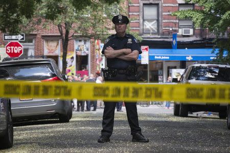 A New York Police Officer stands guard inside a cordoned area at the site of a shooting in Greenwich Village, Manhattan, New York July 28, 2014. REUTERS/Darren Ornitz