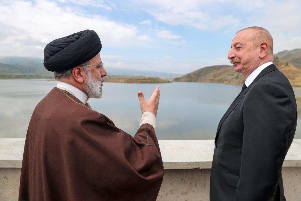 President Ebrahim Raisi (left) speaks with his Azeri counterpart Ilham Aliyev on the inauguration of a dam earlier on Sunday before the accident (AP)