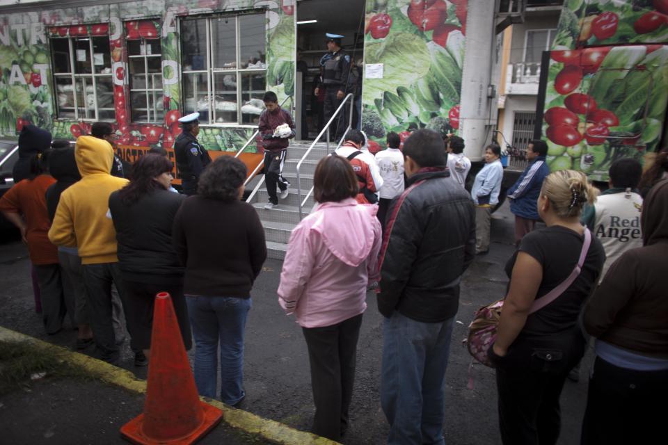 People line up outside a large city truck to buy eggs at government subsidized prices in Mexico City, Friday, Aug. 24, 2012. The Mexican government is battling an egg shortage and hoarding that have caused prices to spike in a country with the highest per-capita egg consumption on earth. About 11 million chickens were slaughtered after a June outbreak of bird flu. (AP Photo/Alexandre Meneghini)