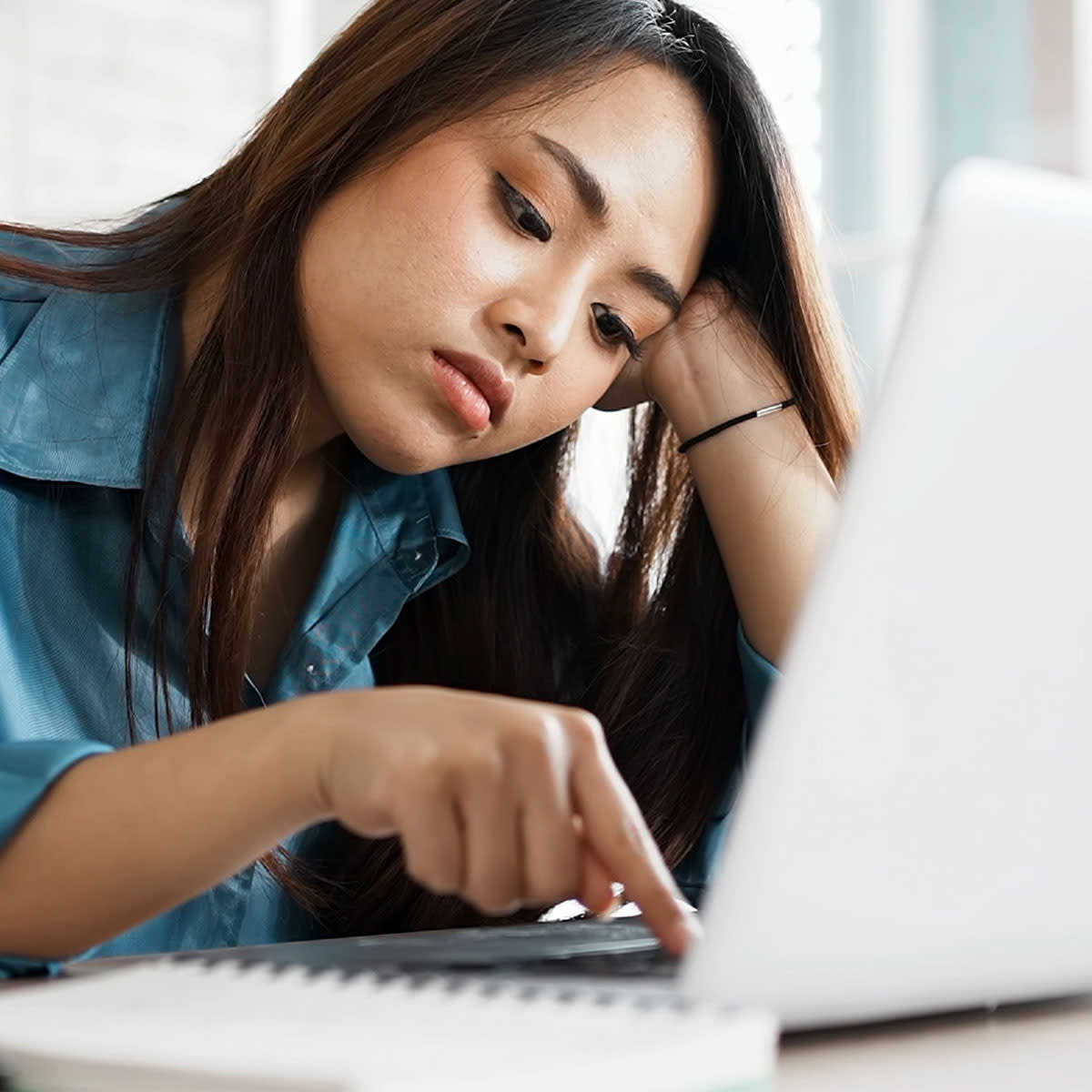 woman looking tired at her laptop