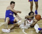 Oklahoma guard Elijah Harkless (24) and Kansas forward Mitch Lightfoot (44) fight for the ball during the second half of an NCAA college basketball game in Norman, Okla., Saturday, Jan. 23, 2021. (AP Photo/Garett Fisbeck)