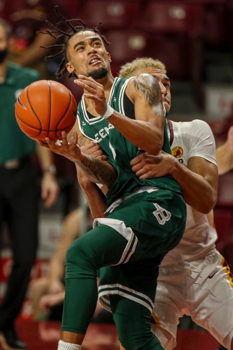 Minnesota forward Jarvis Omersa fouls Green Bay guard Amari Davis (1) during the second half of an NCAA college basketball game Wednesday, Nov. 25, 2020, in Minneapolis. Omersa was called for an intentional foul. (AP Photo/Bruce Kluckhohn)