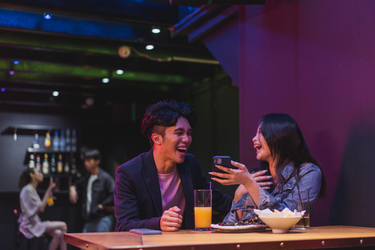 Lifestyle entertainment - Asian young adult couple enjoying the companionship in a bar
