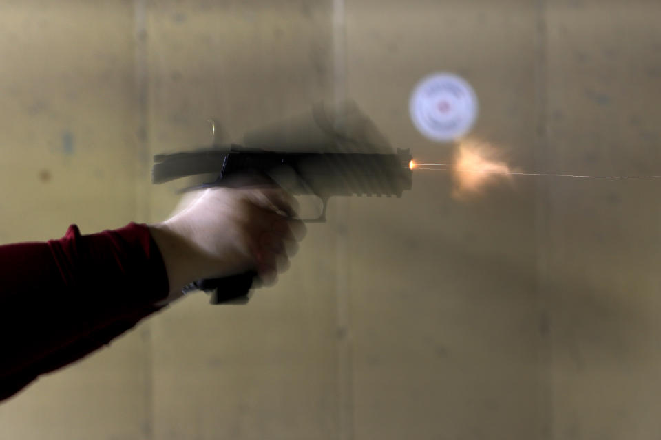 In this Wednesday, Feb. 5, 2020, photo, Kat Ellsworth of Chicago, fires her Sig Sauer P320 X-Five Legion hand gun, one of the seven guns she owns at the Caliber Tactical Gun Range in Waukegan, Ill. Ellsworth was firmly against firearms and favored gun-control until just a few years ago when she went with a friend to a gun range and discovered a love for firearms and shooting. (AP Photo/Charles Rex Arbogast)