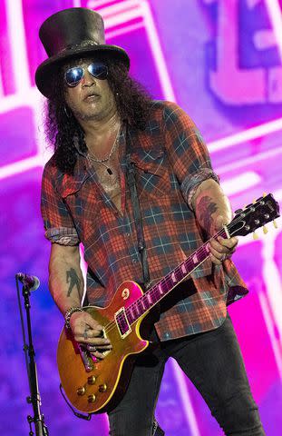 <p>Harry Durrant/Getty </p> Slash performs at Glastonbury in June 2023