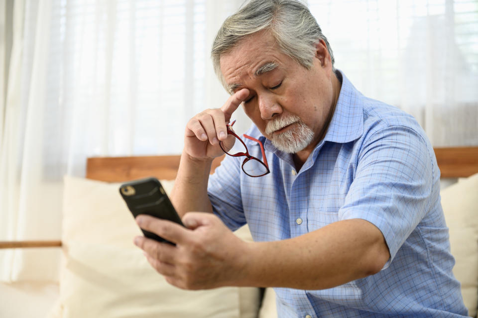 A man looking tired looking at his phone