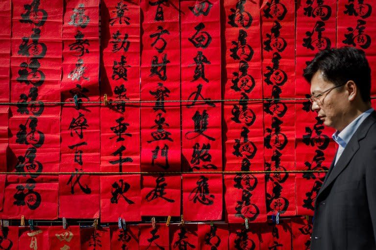 A man walks past Chinese New Year's calligraphy in Hong Kong on February 5, 2013. A stock market slide, possible conflict between Japan and China and more Gangnam-styled success for South Korean singer Psy will shape the incoming Year of the Snake, say Asian soothsayers