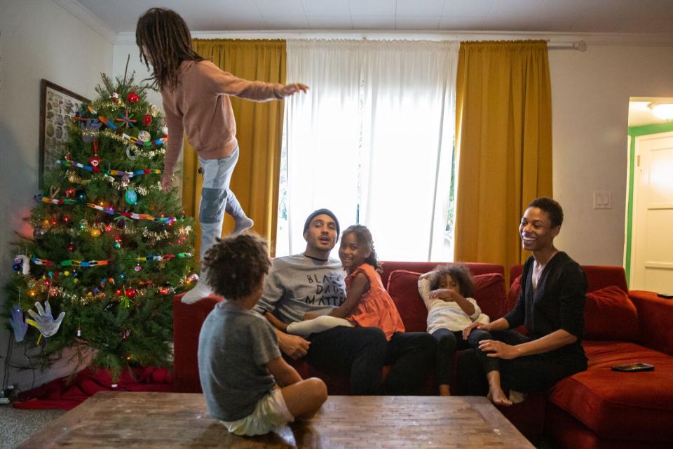 Bobby Brown and his wife, Yhanni, hang out in their living room with their four children.