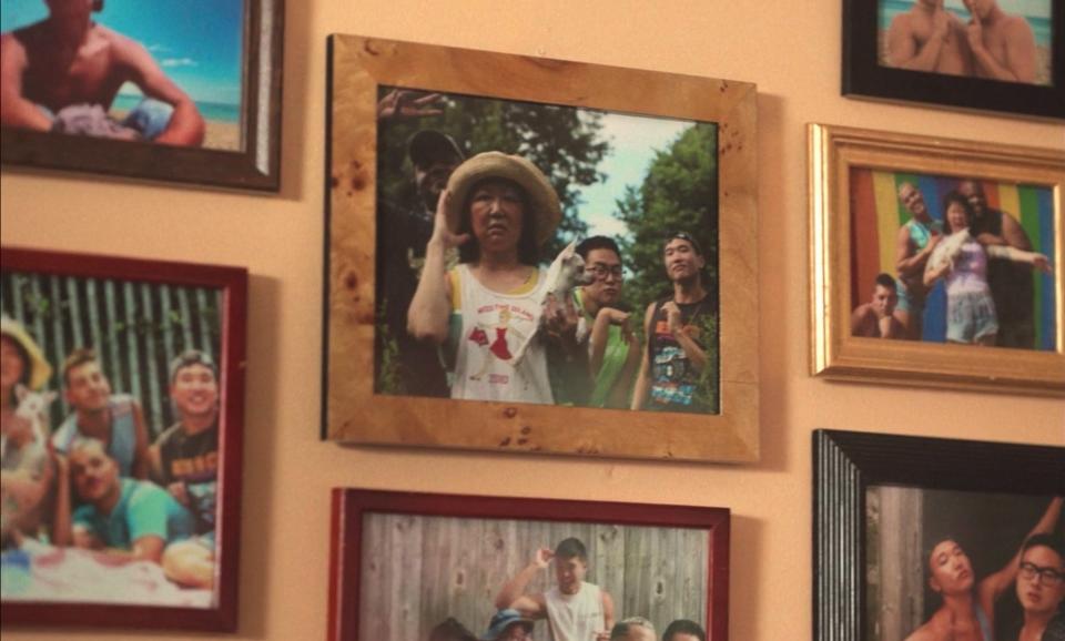 photos on the wall of a chosen family from "Fire Island"