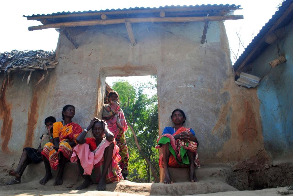 Santhal tribal women sit in a doorway of a home in a village where a woman was gang raped, allegedly on the direction of a village council at Subalpur, in Birbhum district, about 180 kilometers (110 miles) north of Kolkata, the capital of the eastern Indian state of West Bengal, Friday, Jan. 24, 2014. These unelected and unregulated courts now are coming under fresh scrutiny after police say a council of elders in West Bengal ordered the gang rape of a 20-year-old woman as punishment for falling in love with the wrong man. (AP Photo)