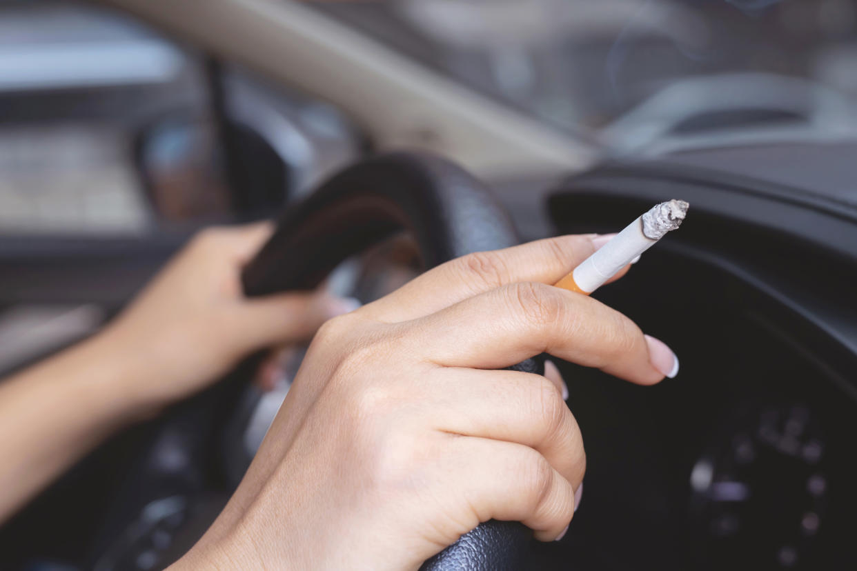 A woman is smoking in a car