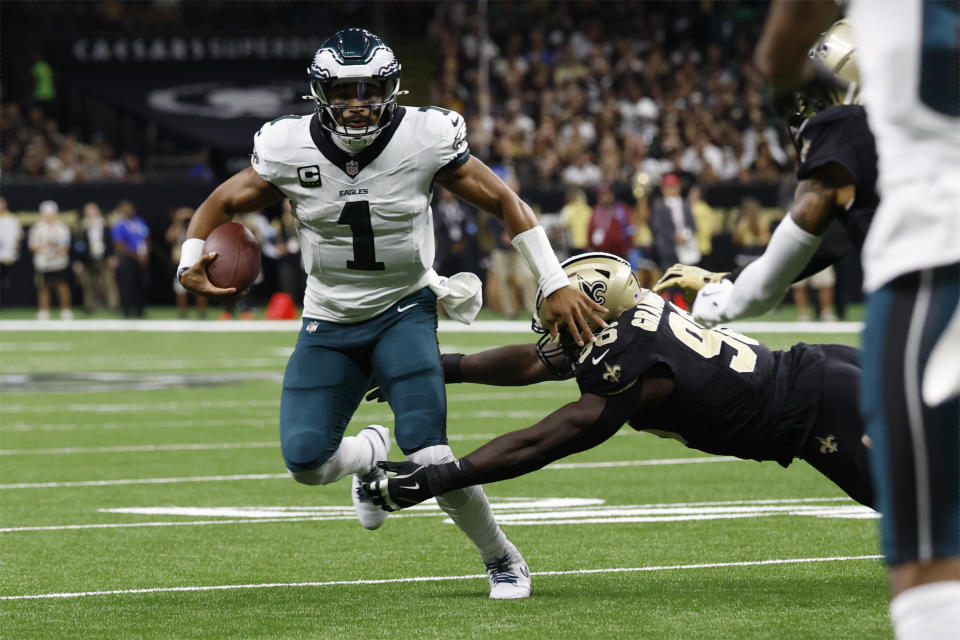 Philadelphia Eagles quarterback Jalen Hurts (1) scrambles past New Orleans Saints defensive end Carl Granderson (96) in the first half of an NFL football game in New Orleans, Sunday, Sept. 22, 2024. (AP Photo/Butch Dill)