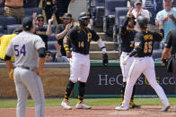 Pittsburgh Pirates' Jack Suwinski (65) celebrates with Michael Chavis (2), and Rodolfo Castro (14) as he crosses home plate after hitting a three-run home run off Colorado Rockies relief pitcher Carlos Estevez (54) during the sixth inning of a baseball game in Pittsburgh, Wednesday, May 25, 2022. The Pirates won 10-5. (AP Photo/Gene J. Puskar)