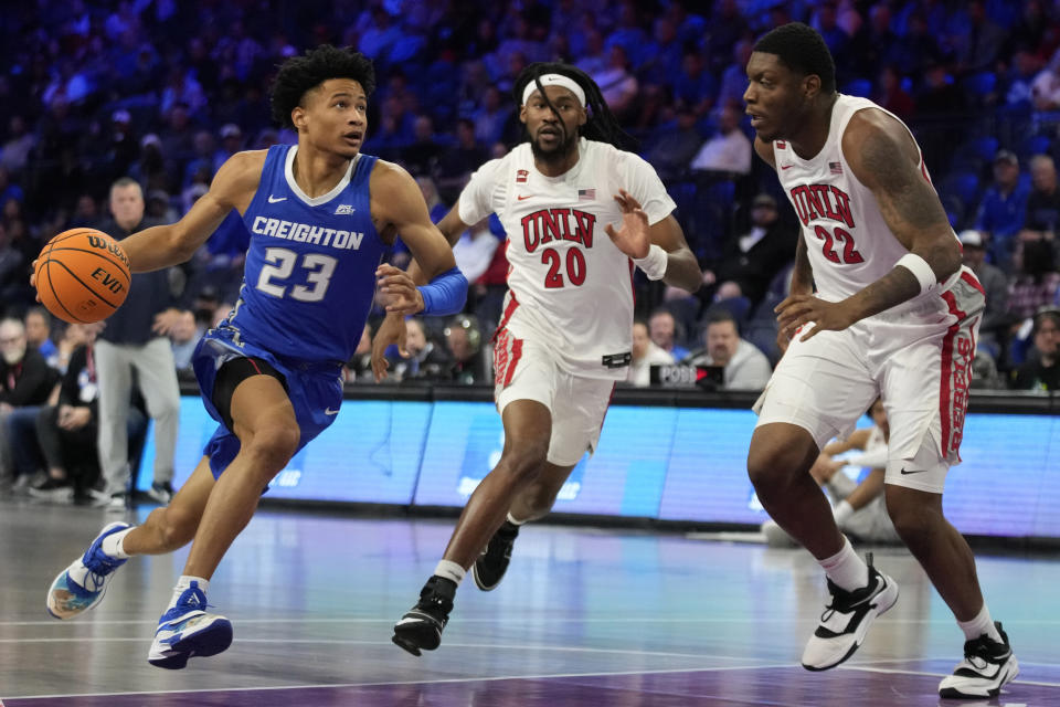 Creighton guard Trey Alexander (23) drives against UNLV forward Keylan Boone (20) and forward Karl Jones (22) during the first half of an NCAA college basketball game Wednesday, Dec. 13, 2023, in Henderson, Nev. (AP Photo/John Locher)