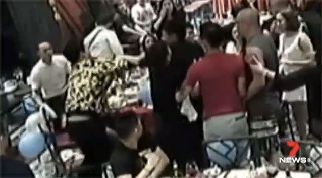 Ma, above left in yellow and black, is seen pushing another man. Picture: 7 News