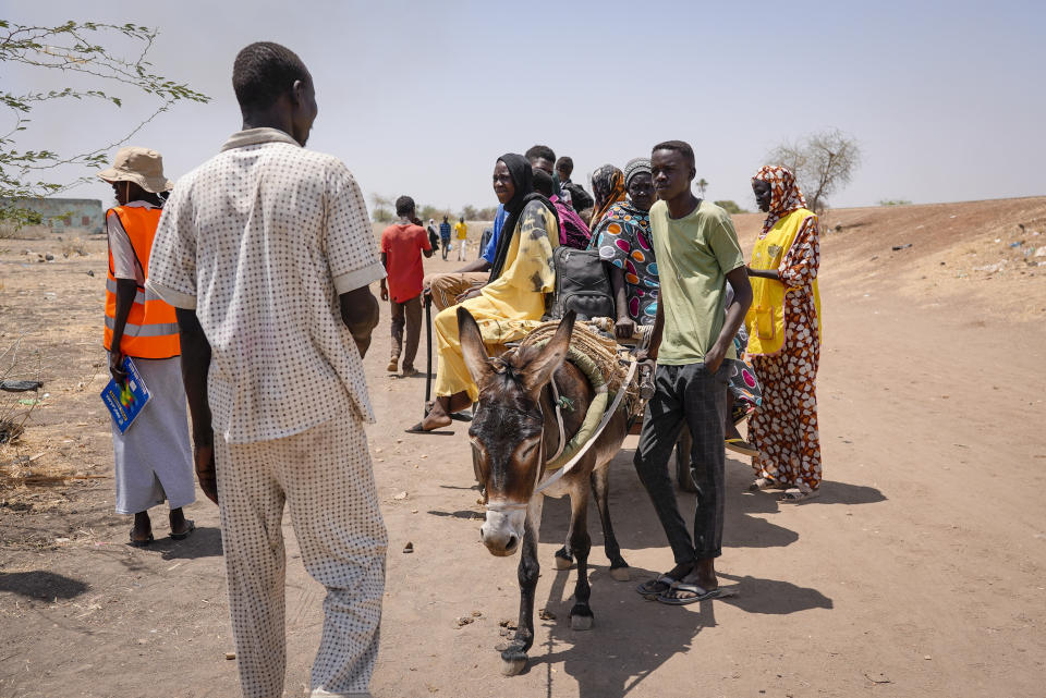 People cross the border from Sudan to South Sudan on a donkey cart and check in with border monitoring staff, at the Joda border crossing in South Sudan Tuesday, May 16, 2023. Tens of thousands of South Sudanese are flocking home from neighboring Sudan, which erupted in violence last month. (AP Photo/Sam Mednick)