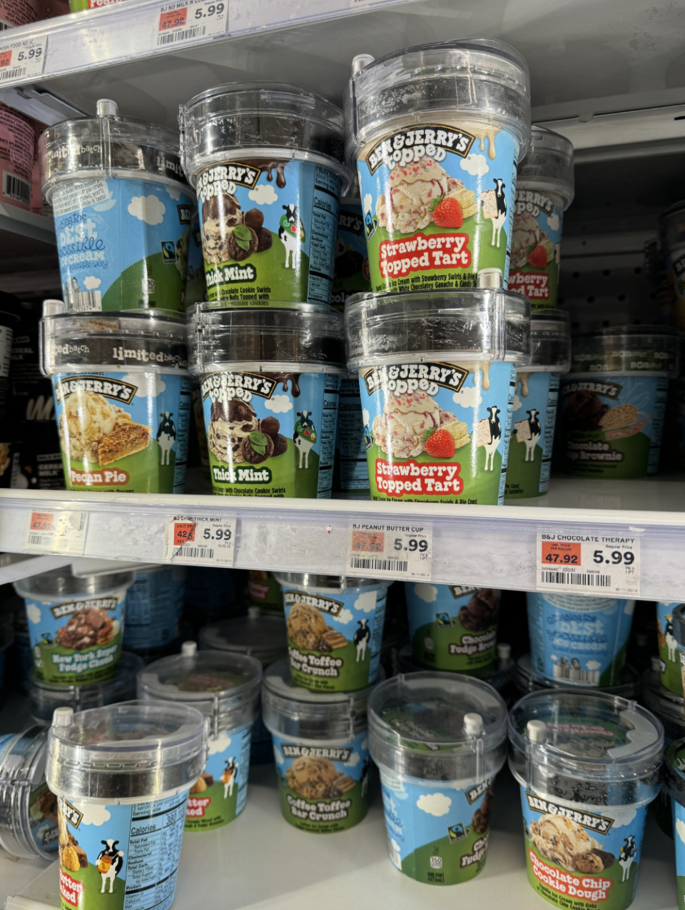 Shelves stocked with various Ben & Jerry's ice cream flavors including Mint Chocolate Cookie and Strawberry Topped Tart