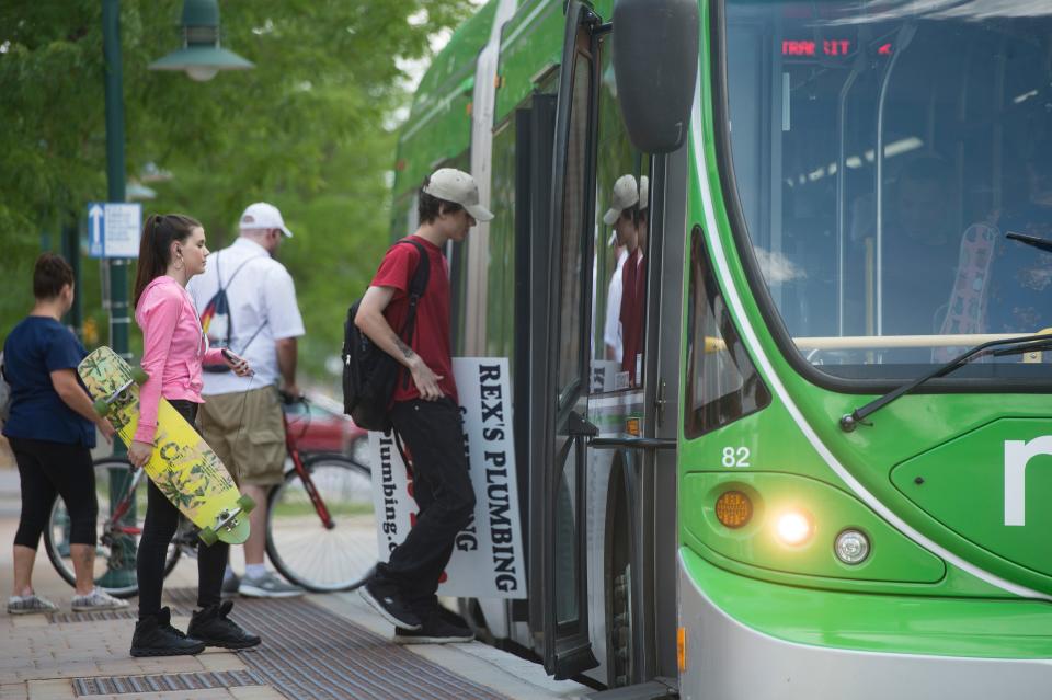 People board a MAX bus at the Fort Collins Downtown Transit Center on June 14, 2018.