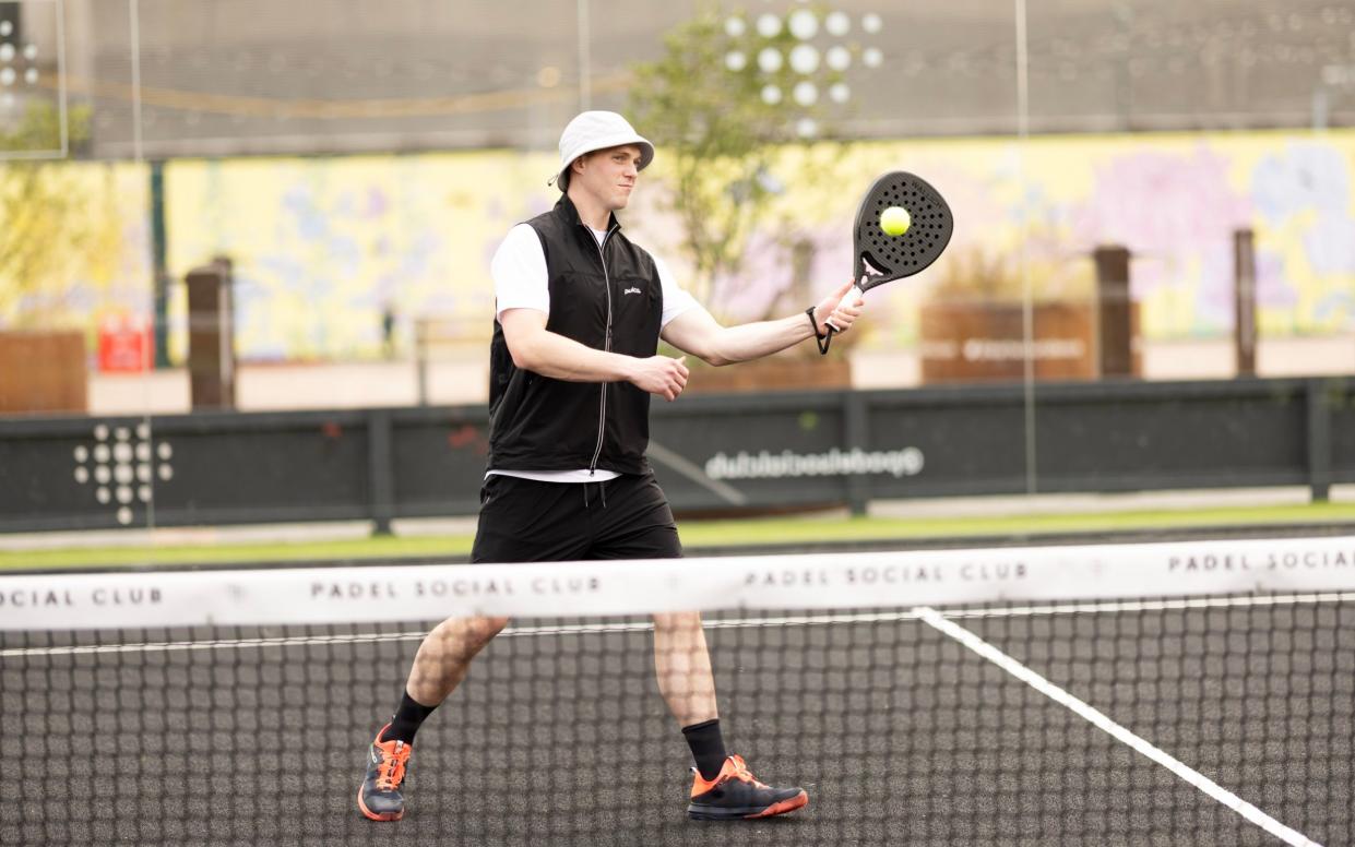 Alex Barton sitting down on the padel court