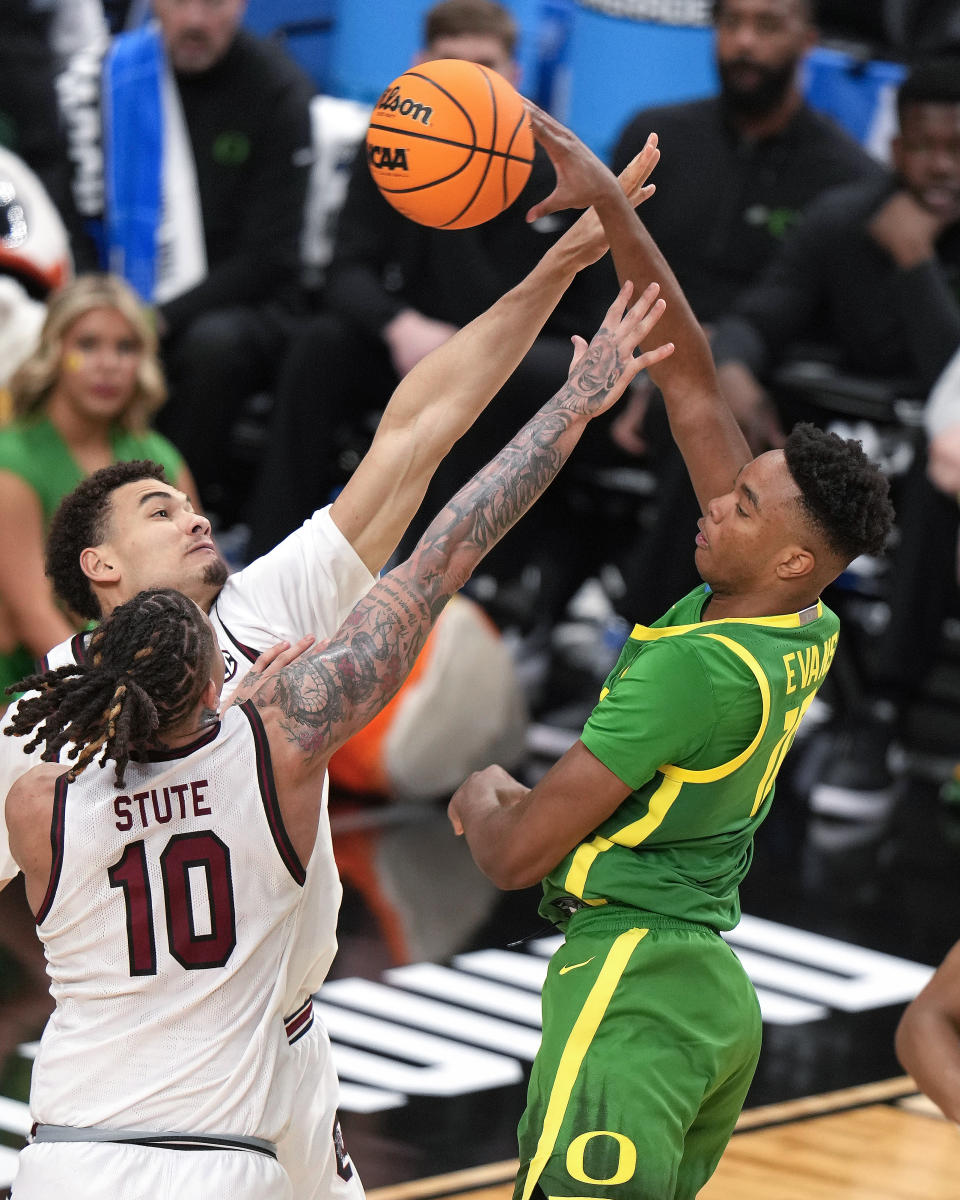 Oregon's Kwame Evans Jr., right, gets off a pass over South Carolina's Myles Stute (10), and Benjamin Bosmans-Verdonk during the second half of a first-round college basketball game in the NCAA Tournament in Pittsburgh, Thursday, March 21, 2024. (AP Photo/Gene J. Puskar)