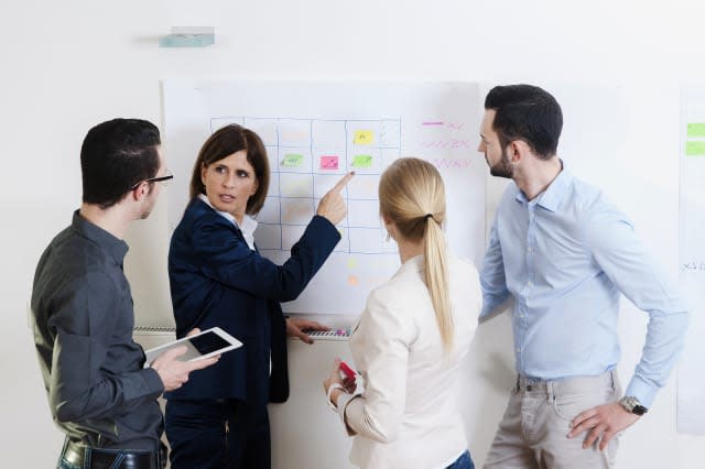 Group of young business people and mature businesswoman in discussion in office, Germany