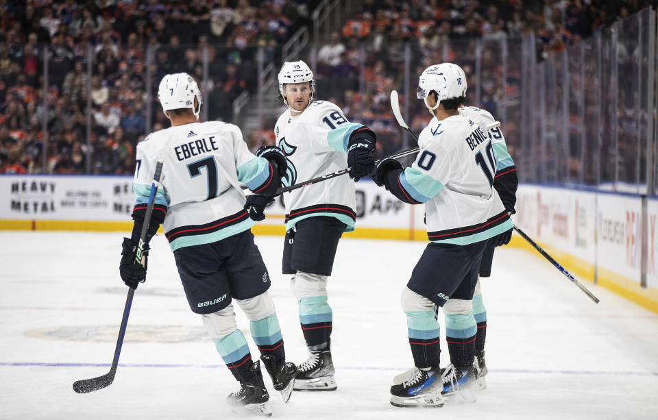 Seattle Kraken's Jordan Eberle (7), Jared McCann (19) and Matty Beniers (10) celebrate a goal against the Edmonton Oilers during the first period of an NHL preseason hockey game Friday, Oct. 6, 2023, in Edmonton, Alberta. (Jason Franson/The Canadian Press via AP)