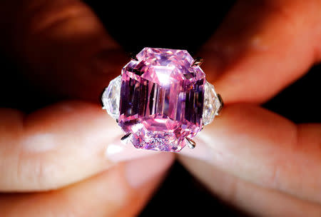 FILE PHOTO: A Christie's staff holds a 18.96 carat Fancy Vivid Pink Diamond during a preview in Geneva, November 8, 2018. REUTERS/Denis Balibouse/File Photo