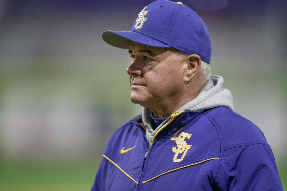 FILE - In this Feb. 14, 2020, file photo, LSU baseball head coach Paul Mainieri watches his players practice before an NCAA college baseball game against Indiana, in Baton Rouge, La. The widely praised NCAA decision to extend the eligibility of spring sports athletes who had their seasons abruptly end because of the coronavirus pandemic creates headaches for baseball and softball coaches who have to manage rosters that could become unwieldy. (AP Photo/Matthew Hinton, Fle)