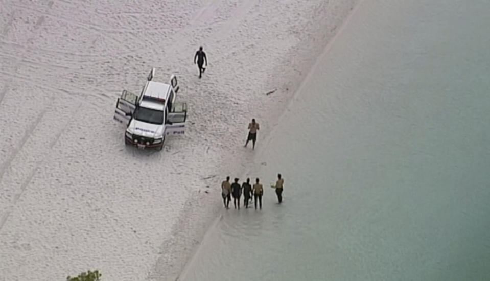 In this image made from video, police divers at Lake McKenzie in Queensland, Australia, Saturday, March 30, 2019. Two Japanese teenagers was found dead in the lake on Saturday morning after being reported missing from a school tour. (Australian Broadcasting Corporation via AP)