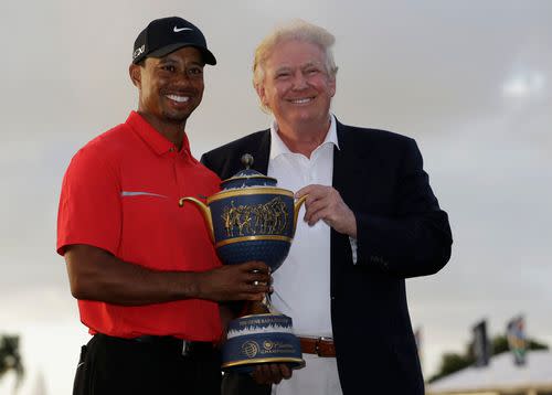 Tiger Woods stands with Donald Trump as he holds the Gene Serazen Cup for winning the Cadillac Championship golf tournament Sunday, March 10, 2013, in Doral, Fla. Woods won with a score 19-under-par 269.
