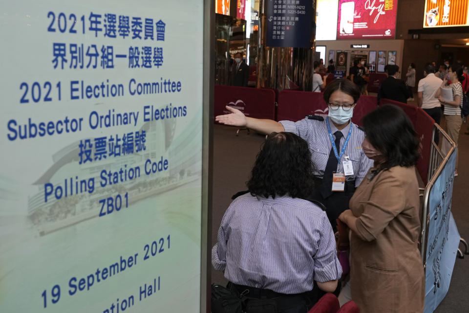 Voters enter a polling center for the election committee that will vote for the city's leader in Hong Kong Sunday, Sept. 19, 2021. Hong Kong's polls for an election committee that will vote for the city's leader kicked off Sunday amid heavy police presence, with chief executive Carrie Lam saying that it is "very meaningful" as it is the first election to take place following electoral reforms. (AP Photo/Vincent Yu)